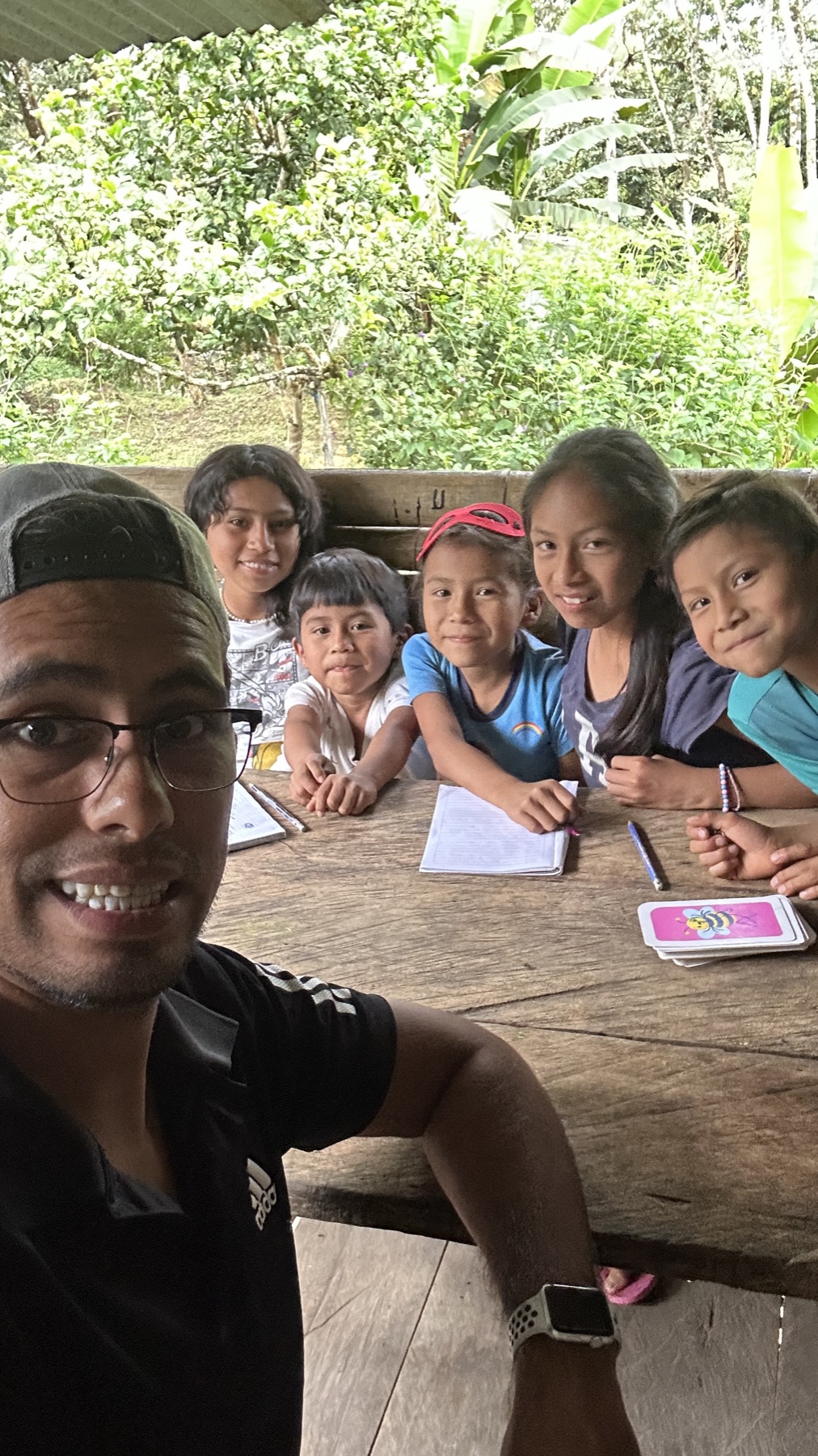 Raul sitting with children during a community activity